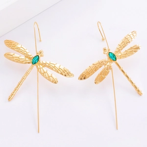 Détail macro de boucles d'oreilles libellule avec pierre marquise verte et ailes dorées