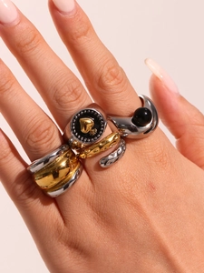 Detail shot of multi-layered stackable chunky rings with gold heart and enamel textures