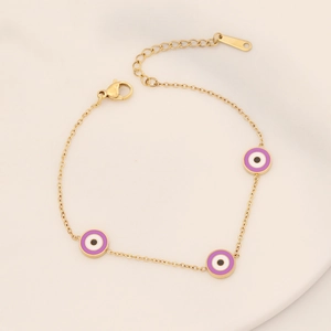 Detailed macro view of purple evil eye charms on a gold plated stainless steel bracelet