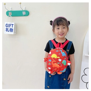 Detail showing red kids dinosaur backpack with colorful prints and sturdy top handle