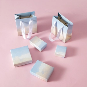 Detail of jewelry gift packaging set featuring blue sky and white cloud oil painting patterns