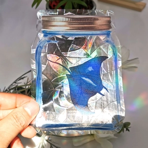 Detailed macro of a handmade rainbow suncatcher sticker with blue manta ray in mason jar