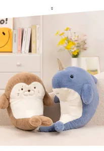Close-up of plush brown seal and blue narwhal toys on a soft fabric sofa in home setting