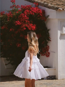 Detail of white tiered ruffle sundress featuring spaghetti straps and lightweight fabric