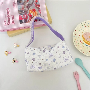 Detail of white bubble canvas tote with purple cartoon bears and lace-trimmed straps