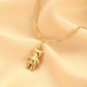 Detailed close-up of golden bear pendant necklace with stylish mixed-link chain design