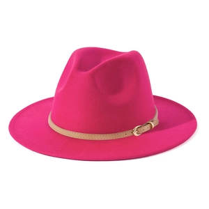 Detail of rose red wool felt fedora hat featuring a light brown leather band with gold buckle