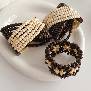 Detail of handcrafted bohemian wood bead bracelets in dark brown and ivory cream tones