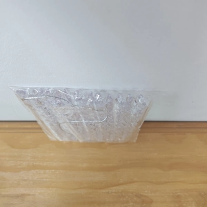 Detailed view of clear acrylic icicle ornaments with silver strings in plastic packaging