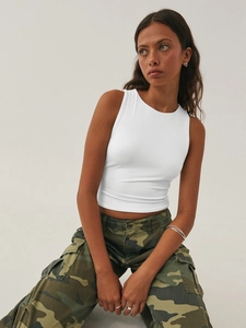 Detail of white crop tank top paired with camouflage cargo pants for Y2K street style