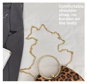 Detail of leopard print evening bag with golden ring handle and ball clasp closure