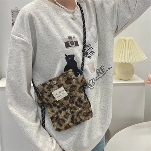 Détail du sac bandoulière en peluche léopard avec fourrure et sangle tissée