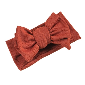Deep rust red knitted baby headband featuring a large double-layer jacquard bow design