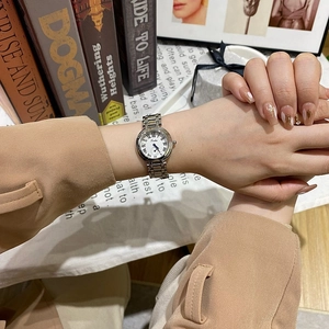 Gros plan de montre femme avec cadran à chiffres romains et bracelet métallique bicolore