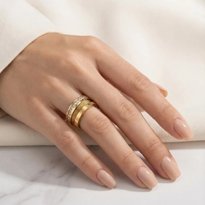 Detail of gold multi-layer ring with Roman numeral engravings and inlaid rhinestones