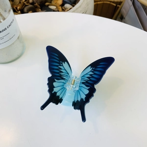 Blue gradient butterfly hair claw clip with realistic wing texture on white background