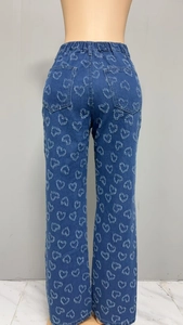 Detailed close-up showing heart-shaped frayed patterns on the blue denim trousers