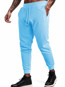 Detail view of light blue waffle knit fabric joggers with drawstring elastic waistband