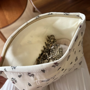 Internal view of floral cotton makeup bag showing capacity and zip closure detail