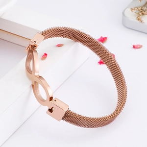 Macro shot of rose gold infinity symbol charm on a Milanese mesh stainless steel bracelet