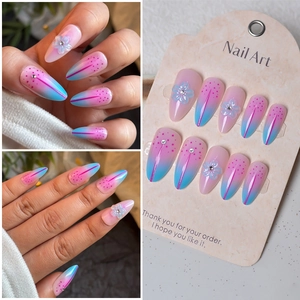 Detailed view of 3D floral almond press-on nails with pink and blue gradient and rhinestones
