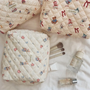 Vue détaillée de la trousse cosmétique matelassée avec motifs ours et texture tissu