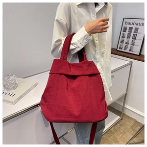 Close-up of deep red large nylon tote bag with dual handles and long shoulder strap
