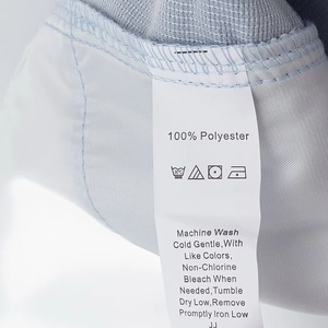 Détail de l'étiquette d'entretien sur tissu en polyester bleu clair avec symboles