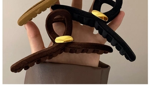 Détail de pinces à cheveux géométriques en flocage couleurs marron, noir et gingembre