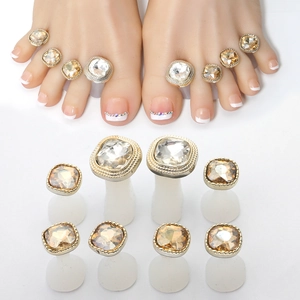 Close-up of 10-piece gold and silver toe ring set with champagne and clear gemstones