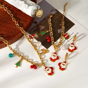 Détail de parure de bijoux de Noël avec breloques en émail doré et accents de perles