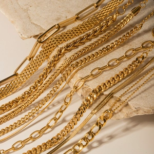 Collection de bracelets gourmettes en acier inoxydable doré sur socle en pierre