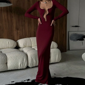 Détail de la robe moulante bordeaux avec décolleté en U profond et boules métalliques