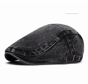 Close-up of black washed denim flat cap with adjustable metal buckle and stitching