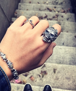Parure de bijoux gothiques avec bagues tête de mort et bracelet chaîne sur une main d'homme