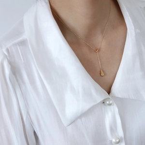 Collier en Y plaqué or 18k avec pendentif goutte d'eau minimaliste sur chemise blanche