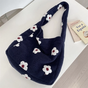 Dettaglio della borsa tote blu in peluche con motivi floreali e morbida texture