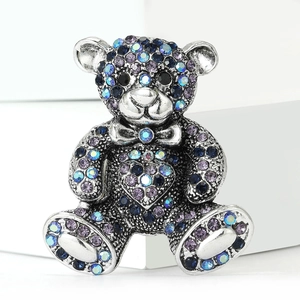 Detailed close-up of a silver teddy bear brooch set with sparkling multicolored rhinestones