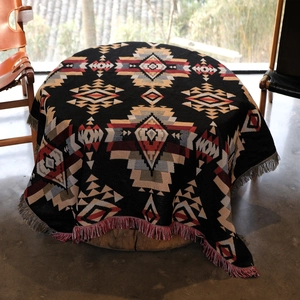 Bohemian style woven picnic blanket with colorful tassels and geometric patterns