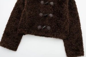 Detail of faux fur coat with decorative toggle closures and dark brown plush fabric