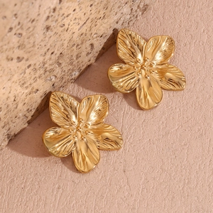 Macro shot of gold-plated 18k floral earrings with detailed brushed petal texture