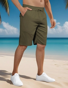Outdoor shot of men's olive green sports shorts featuring a drawstring elastic waist