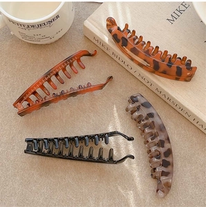 Detail of four vintage French banana clips in black and tortoiseshell finishes on a table