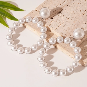 Boucles d'oreilles créoles avec perles blanches et tiges en argent sur pierre