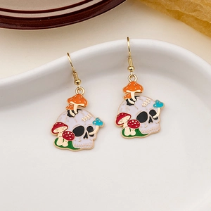 Macro detail of gothic skull and colorful mushroom drop earrings with gold finish