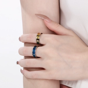 Close-up of gold and blue couple rings with 'The only' engraving and diamond inlay