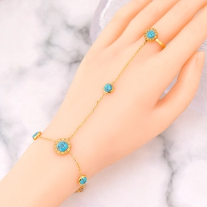 Gold-tone ring bracelet with green turquoise inlay and Roman numeral dial design