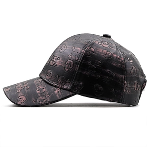 Close-up of embossed skull patterns and dark red brushed finish on black PU baseball cap
