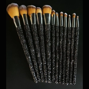 Detailed view of 12 luxury makeup brushes with black rhinestone handles and silver ferrules