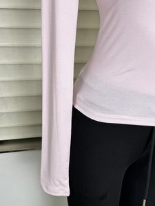 Detail of pink slim fit T-shirt showing fabric texture and curved hemline waist fit